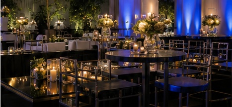 Elegant evening event setup with tables, florals, and architectural lighting